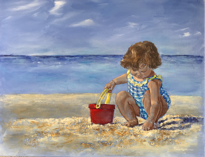 girl on a beach with a red bucket digging in the sand