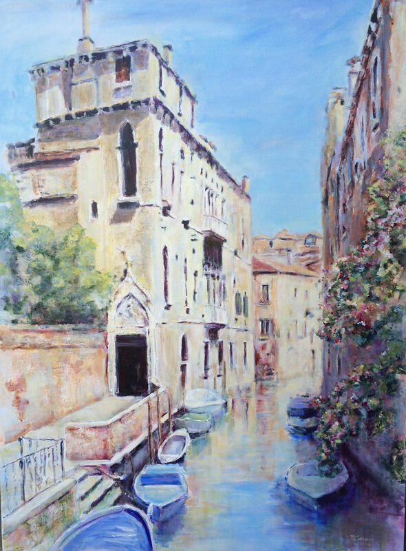 canal in venice with boats, buildings and flowers