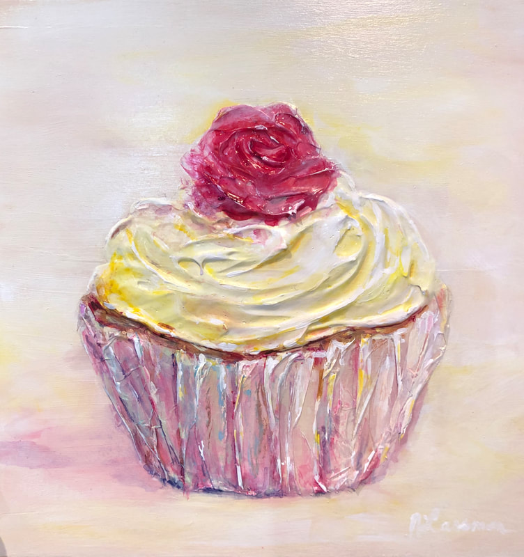 yellow icing cupcake with a pink rose on wood 
